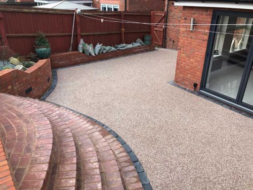 Paved outdoor area with curved steps and landscaped borders.
