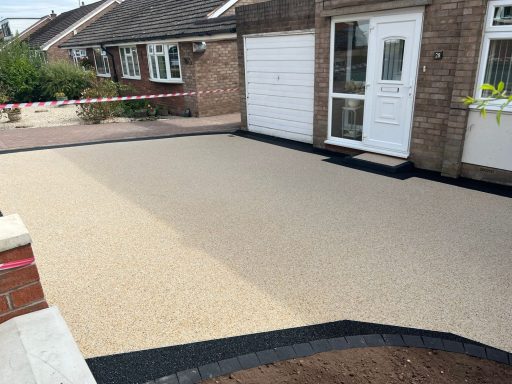 Driveway featuring a smooth, two-toned surface with a concrete border.