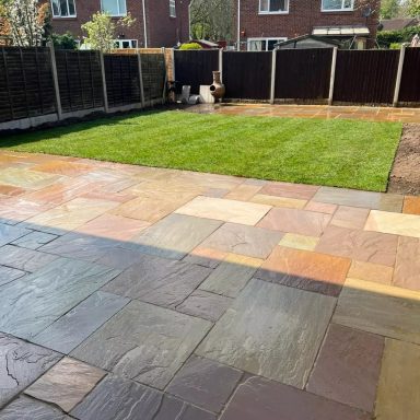 Garden space featuring a neatly manicured lawn and newly laid sandstone patio.