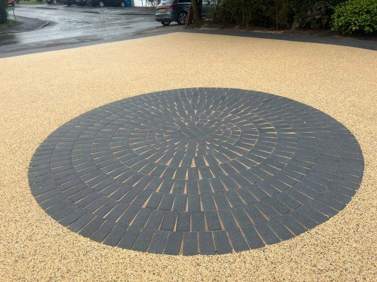 Circular stone mosaic pattern on a textured surface.