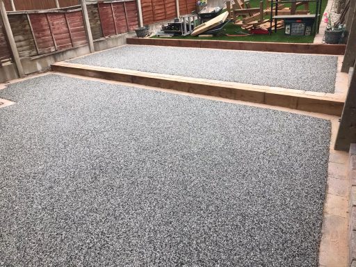 Gravelled garden area with wooden borders and a landscaped background.