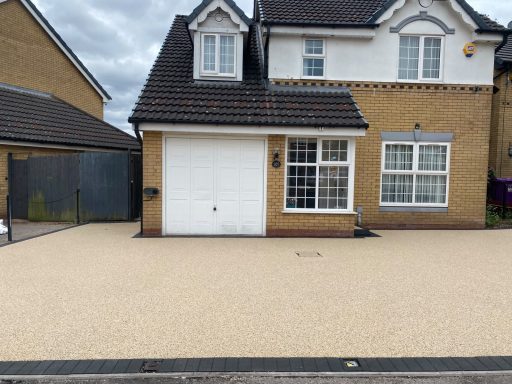 A modern brick house with a single garage and a light-coloured driveway.