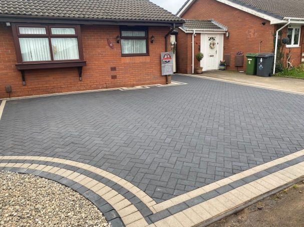 Block Paving Paved driveway with brick edging outside a red brick house.