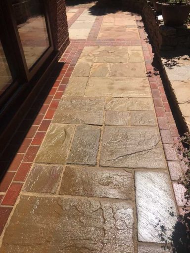 Pathway featuring a mix of sandstone and red brick paving.