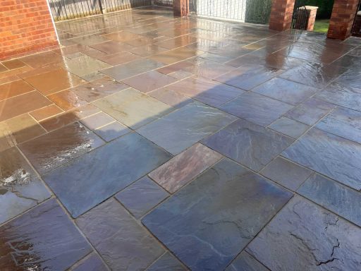 Wet slate patio with varied colours and textures, reflecting light.