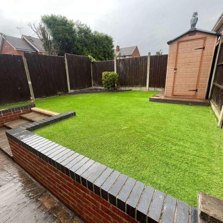 Neatly maintained garden with artificial grass and a small shed in the background.