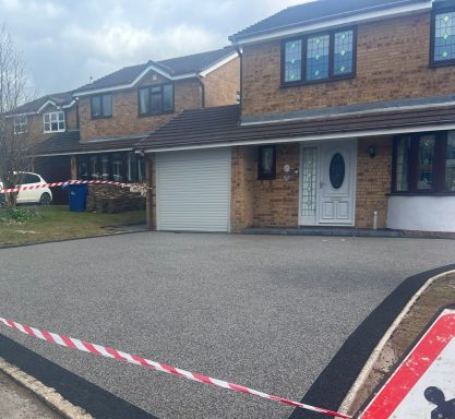 House with a front driveway, surrounded by barrier tape and nearby parked cars.