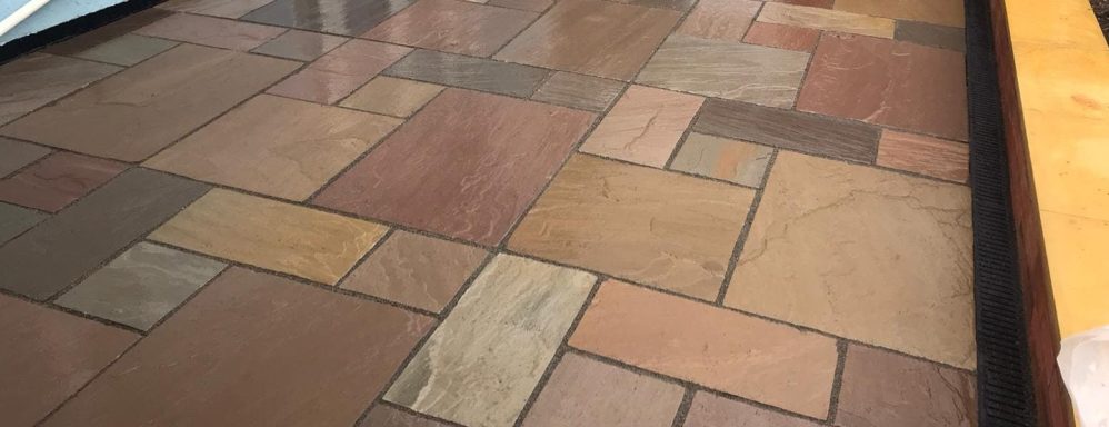Textured floor made of various coloured stones in a patchwork design.