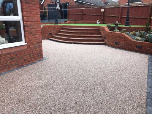 Paved garden area with steps and landscaped borders in a residential setting.